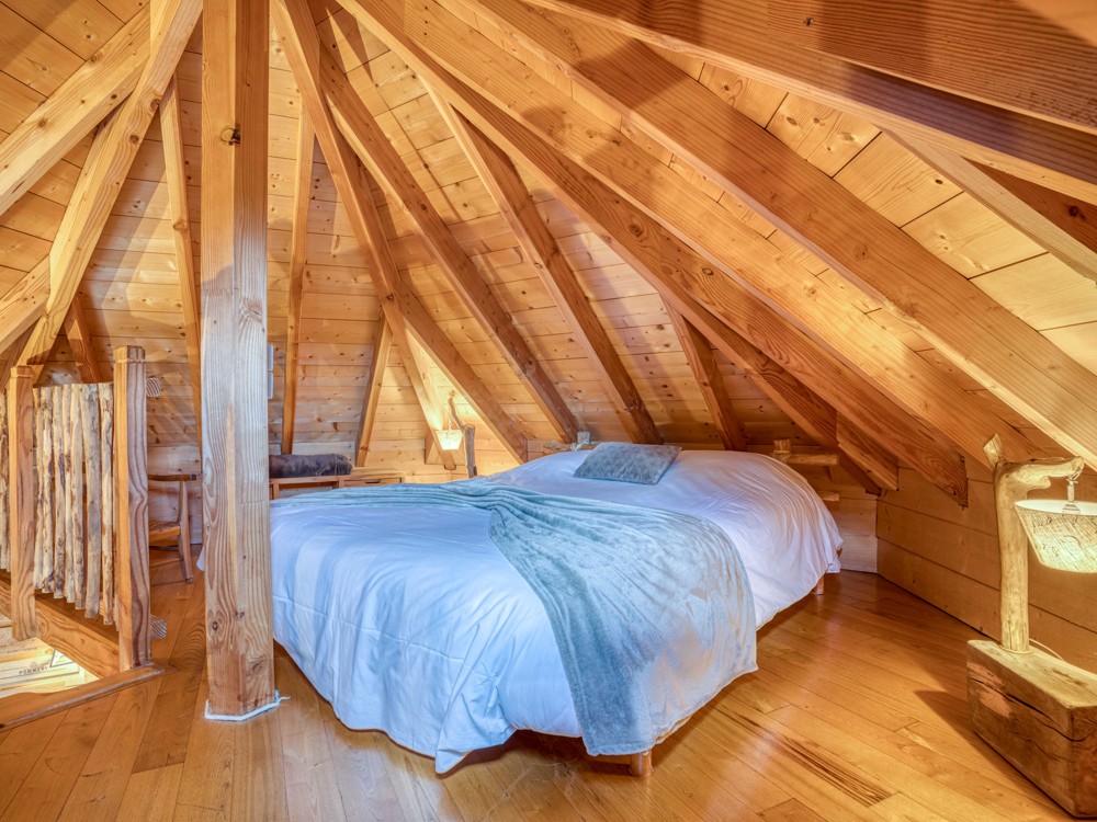 Le lit double sur la mezzanine de la cabane Perigord
